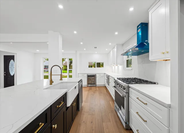 a large kitchen with stainless steel appliances granite countertop a lot of counter space and wooden floors