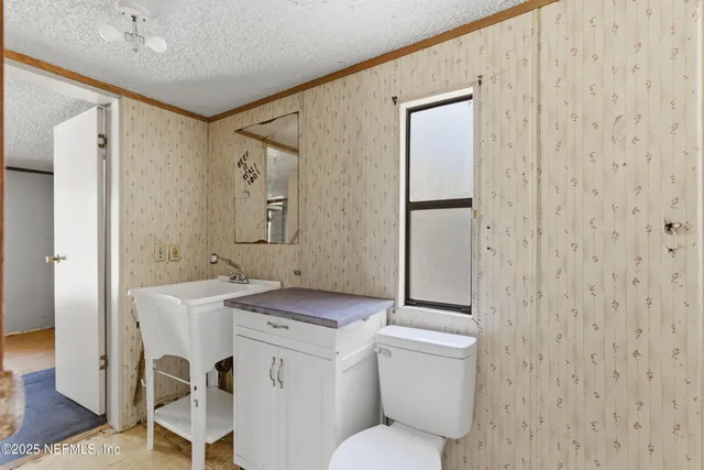 a bathroom with a toilet sink and mirror