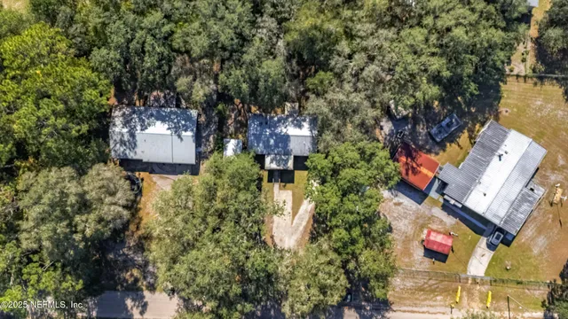 an aerial view of residential houses with outdoor space and trees