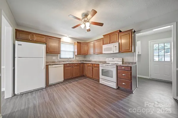 a kitchen with a refrigerator a sink and dishwasher with wooden floor