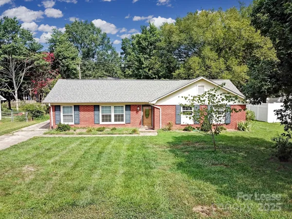 a aerial view of a house next to a big yard and large trees