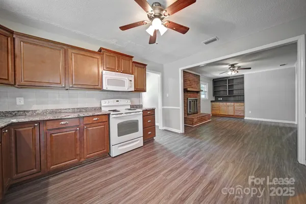 a kitchen with stainless steel appliances granite countertop a stove cabinets and wooden floor