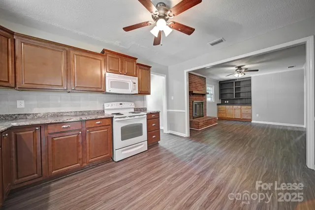 a kitchen with stainless steel appliances granite countertop a stove cabinets and wooden floor