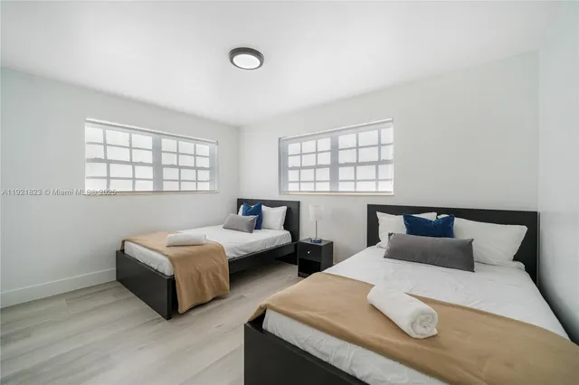 a bedroom with two beds and a large window