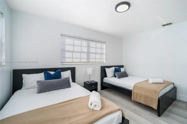 a bedroom with two beds and a window