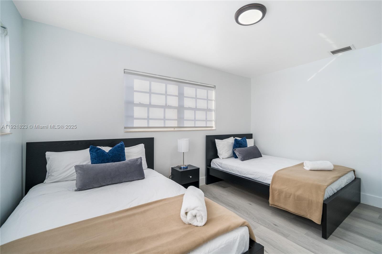 4421 Northwest 9th Street, Unit 4421 Miami, FL 33126 - Photo 8 of 14 a bedroom with two beds and a window