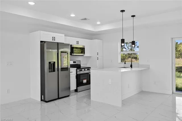 a kitchen with stainless steel appliances a refrigerator sink and stove