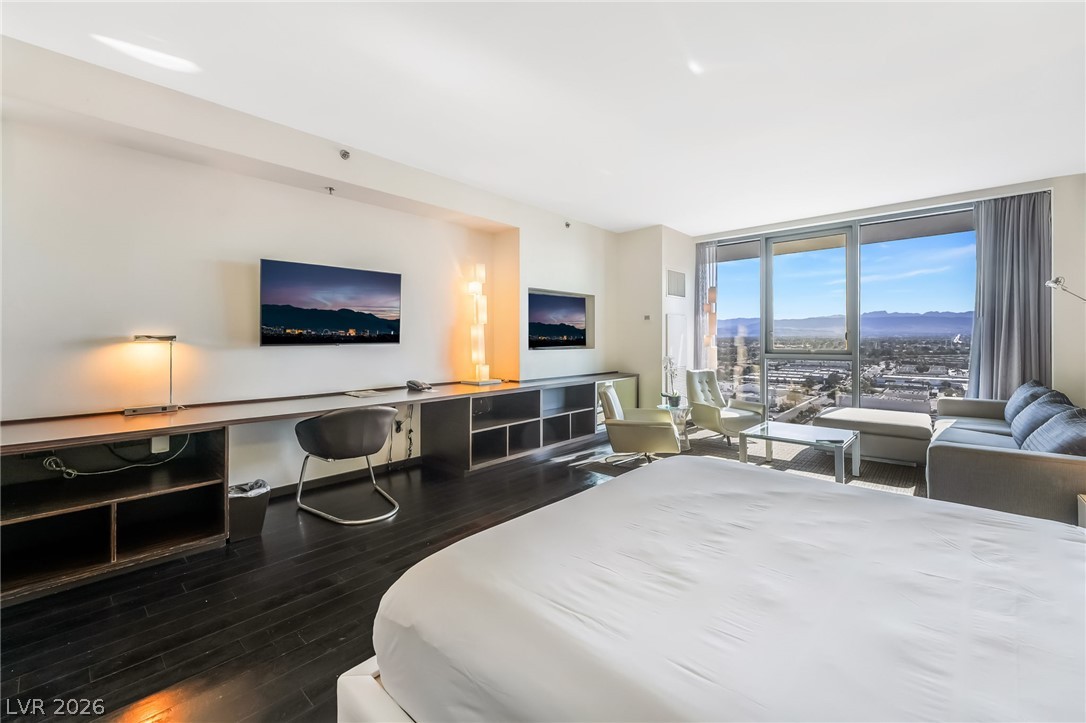 4381 West Flamingo Road, Unit 18305 Las Vegas, NV 89103 - Photo 10 of 19 Floor-to-ceiling windows offer panoramic city and mountain views from this expansive living space.