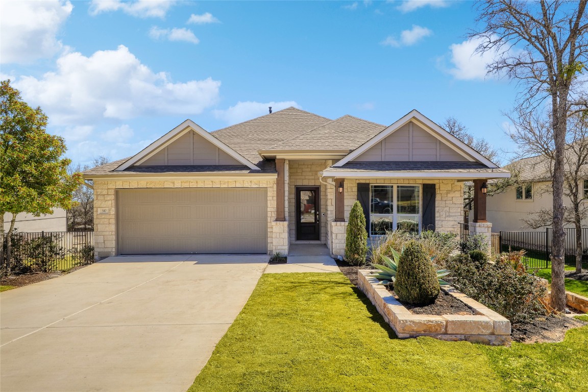 a front view of a house with yard outdoor seating and garage