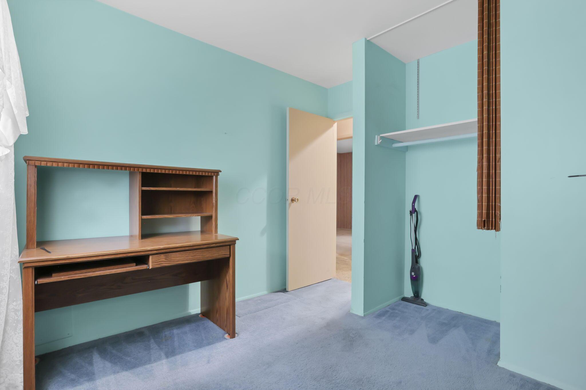 3882 Glenfield Road Columbus, OH 43232 - Photo 18 of 29 Room featuring light blue wall paint, blue carpet flooring, a built-in closet with shelving, and a light-colored interior door