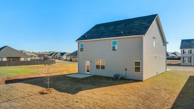a large white kitchen with granite countertop a sink and dishwasher a stove with wooden floors