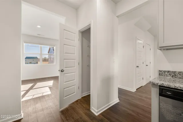 an empty room with wooden floor ceiling fan and windows