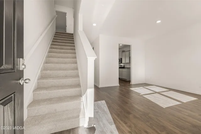 an empty room with wooden floor and a bathroom