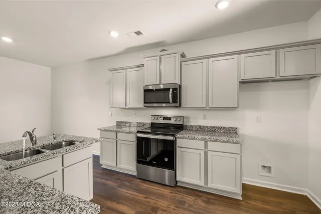 an empty room with windows and ceiling fan