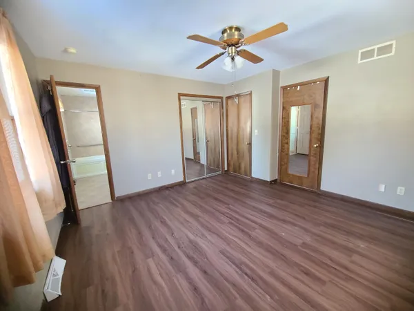 a view of a livingroom with wooden floor and a ceiling fan