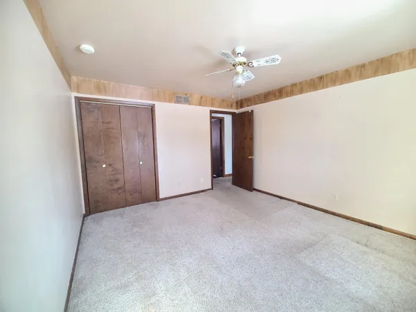 an empty room with windows and closet