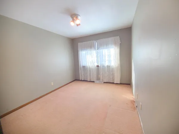 a view of empty room with windows and closet