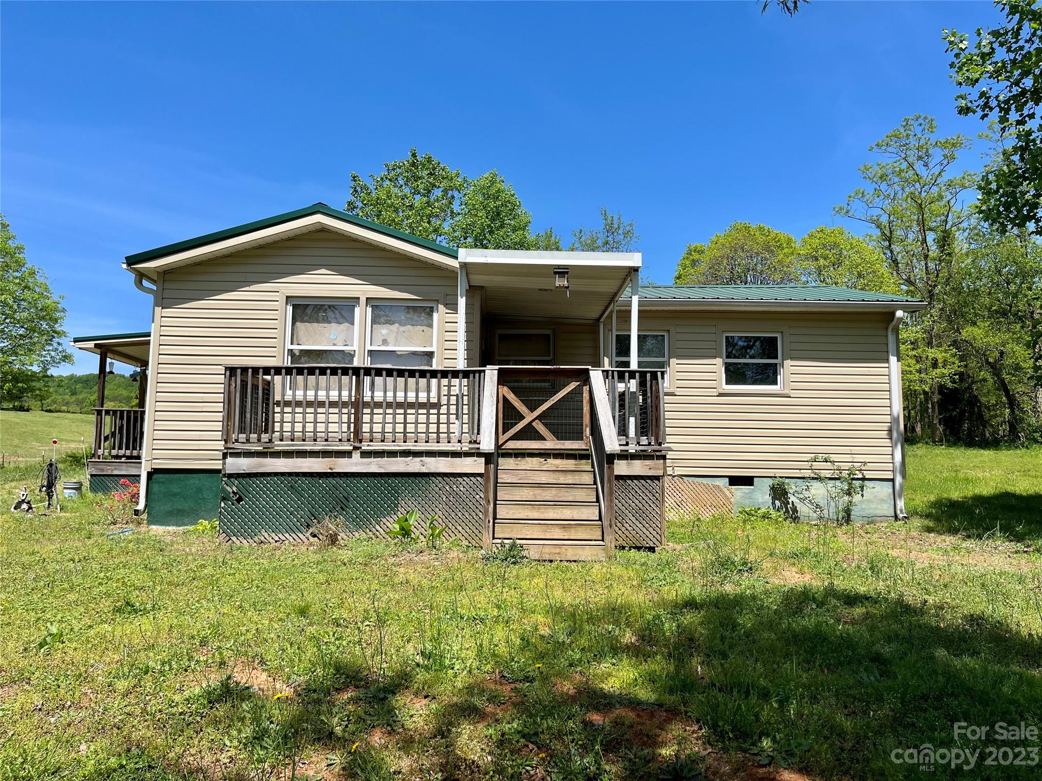 1411 Lackey Mountain Road Hiddenite, NC 28636 - Photo 2 of 19 a front view of a house with garden