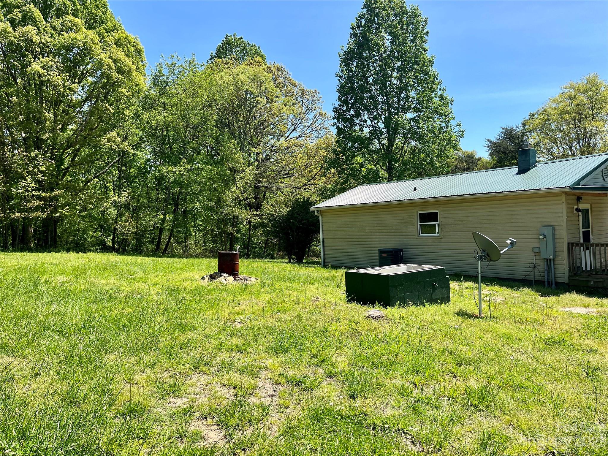 1411 Lackey Mountain Road Hiddenite, NC 28636 - Photo 5 of 19 a backyard of a house with table and chairs