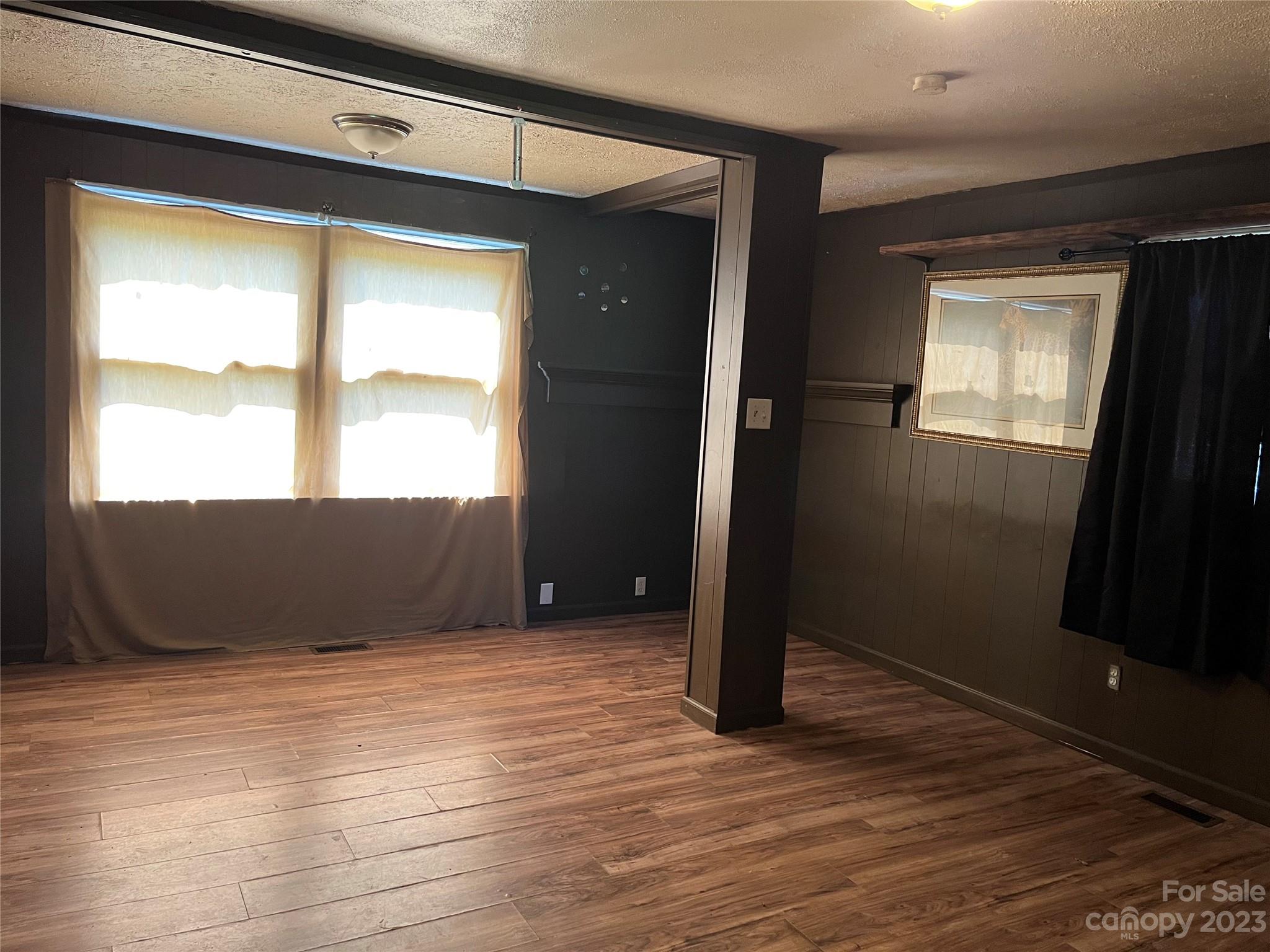 1411 Lackey Mountain Road Hiddenite, NC 28636 - Photo 10 of 19 an empty room with wooden floor and windows