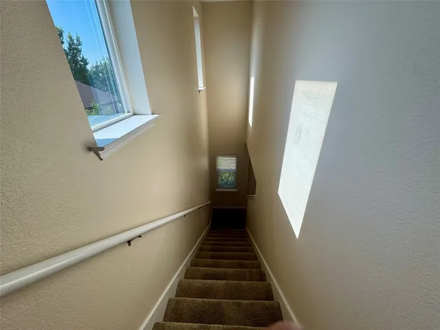 a view of staircase with wooden floor and white walls