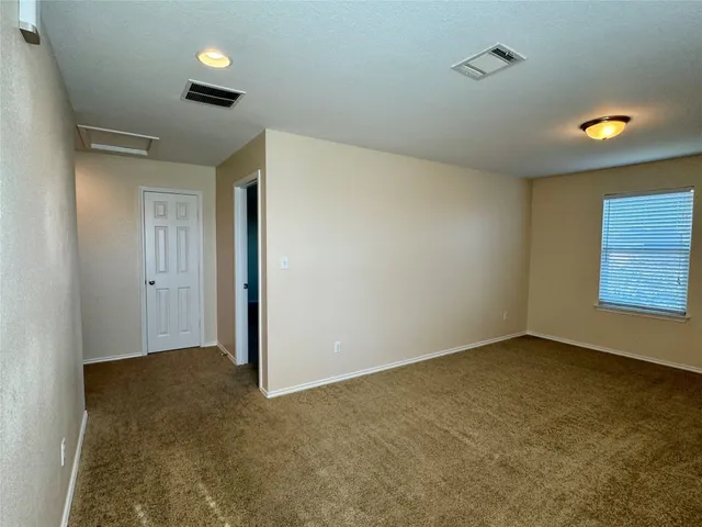 an empty room with windows and cabinet