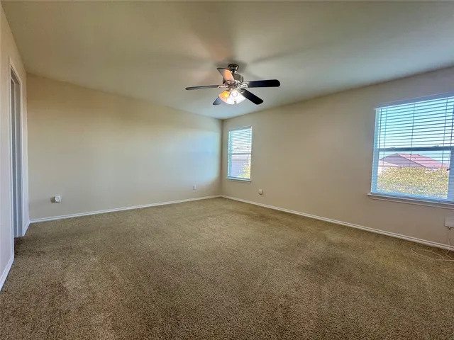 a view of a room with a ceiling fan and a window