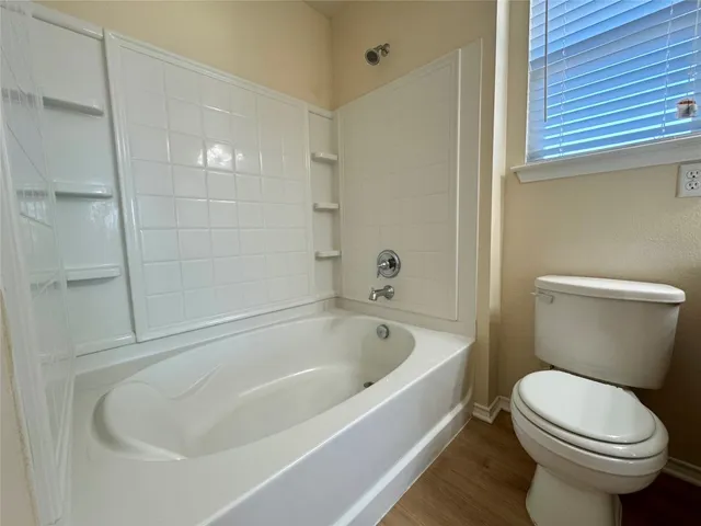a white toilet sitting next to a bath tub