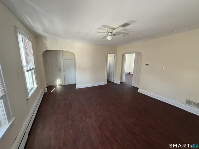 a view of a livingroom with wooden floor and a ceiling fan