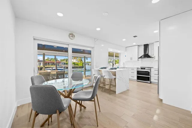 a kitchen with a dining table chairs and large window