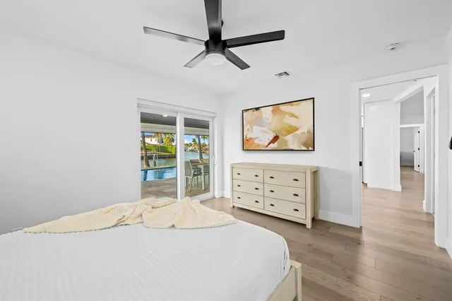 a bedroom with a bed dresser and a flat tv screen