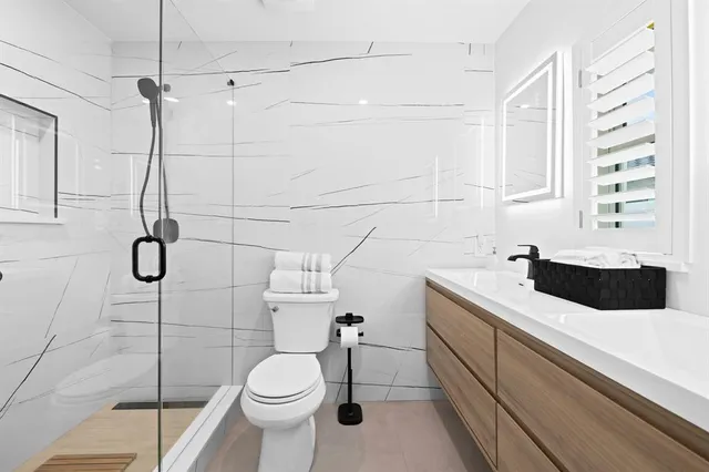 a bathroom with a sink a toilet and shower