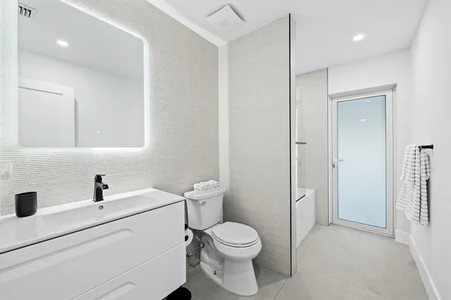 a white toilet sitting next to a bathroom sink