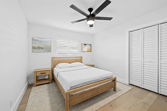a bedroom with a bed and a ceiling fan