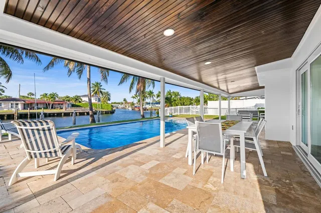 a view of a patio with a dining table and chairs with wooden floor
