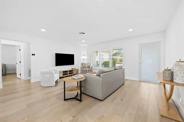a living room with furniture and a flat screen tv with wooden floor