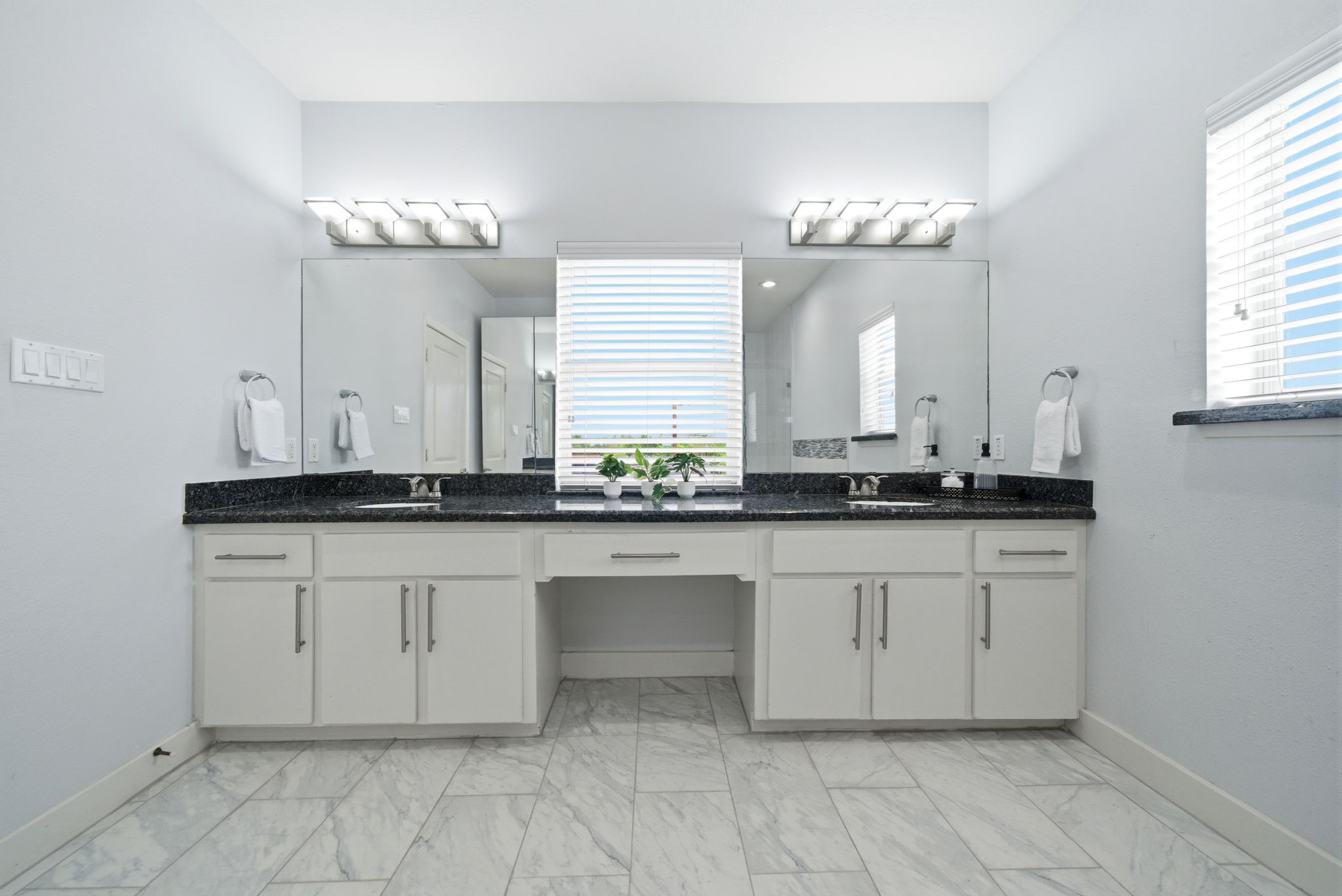 1910 Fletcher Street Houston, TX 77009 - Photo 28 of 34 Double vanity sinks in the primary bathroom, beautiful finishes including lighting, Quartz countertops, shelving and drawers for storage space.