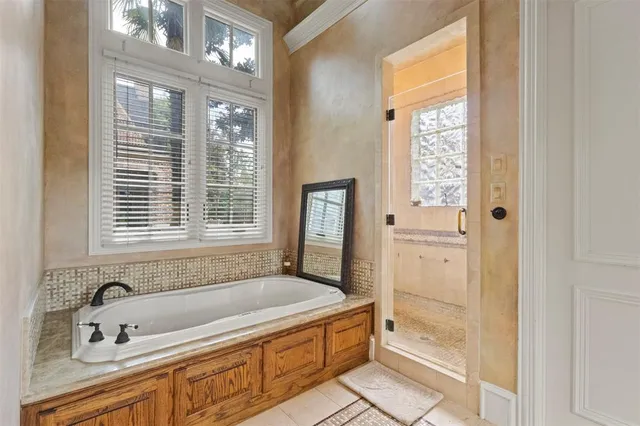 a bathroom with a tub a sink and a window