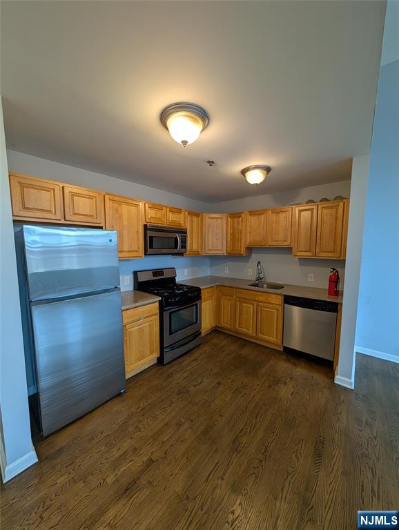 19 Market Street, Unit 405 Paterson, NJ 07501 - Photo 3 of 14 a kitchen with stainless steel appliances kitchen island granite countertop a stove a sink and a refrigerator