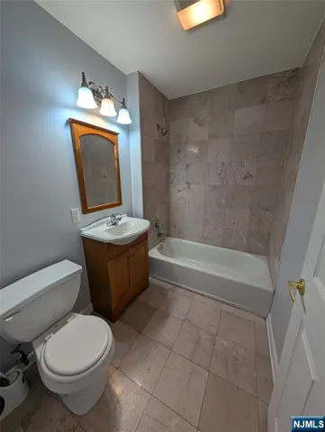a bathroom with a granite countertop toilet a sink and bathtub