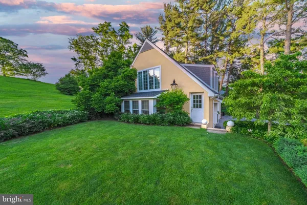 a aerial view of a house next to a big yard and large trees