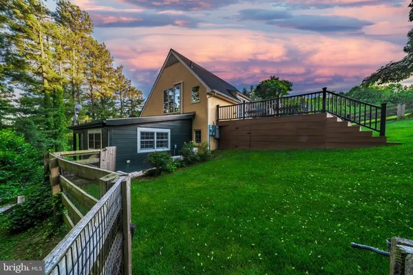 a view of an house with backyard and porch