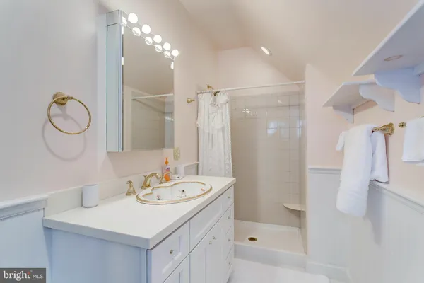 a bathroom with a sink a toilet a mirror and shower