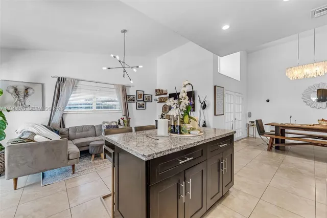 a kitchen with a stove a kitchen island a sink and a refrigerator