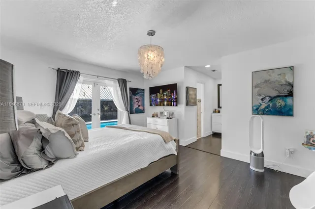 a spacious bedroom with a large bed and a chandelier