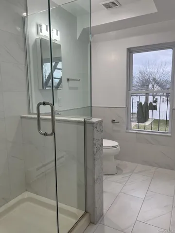a bathroom with a granite countertop toilet a sink and shower