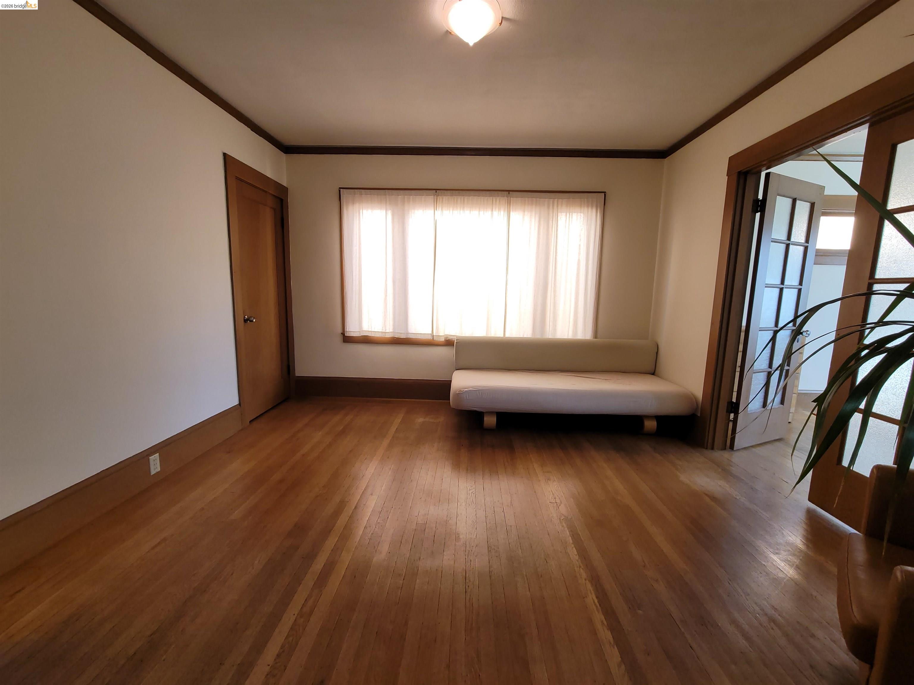 1901 Parker Street, Unit 3 Berkeley, CA 94704 - Photo 10 of 27 a living room with a wooden floor and a window