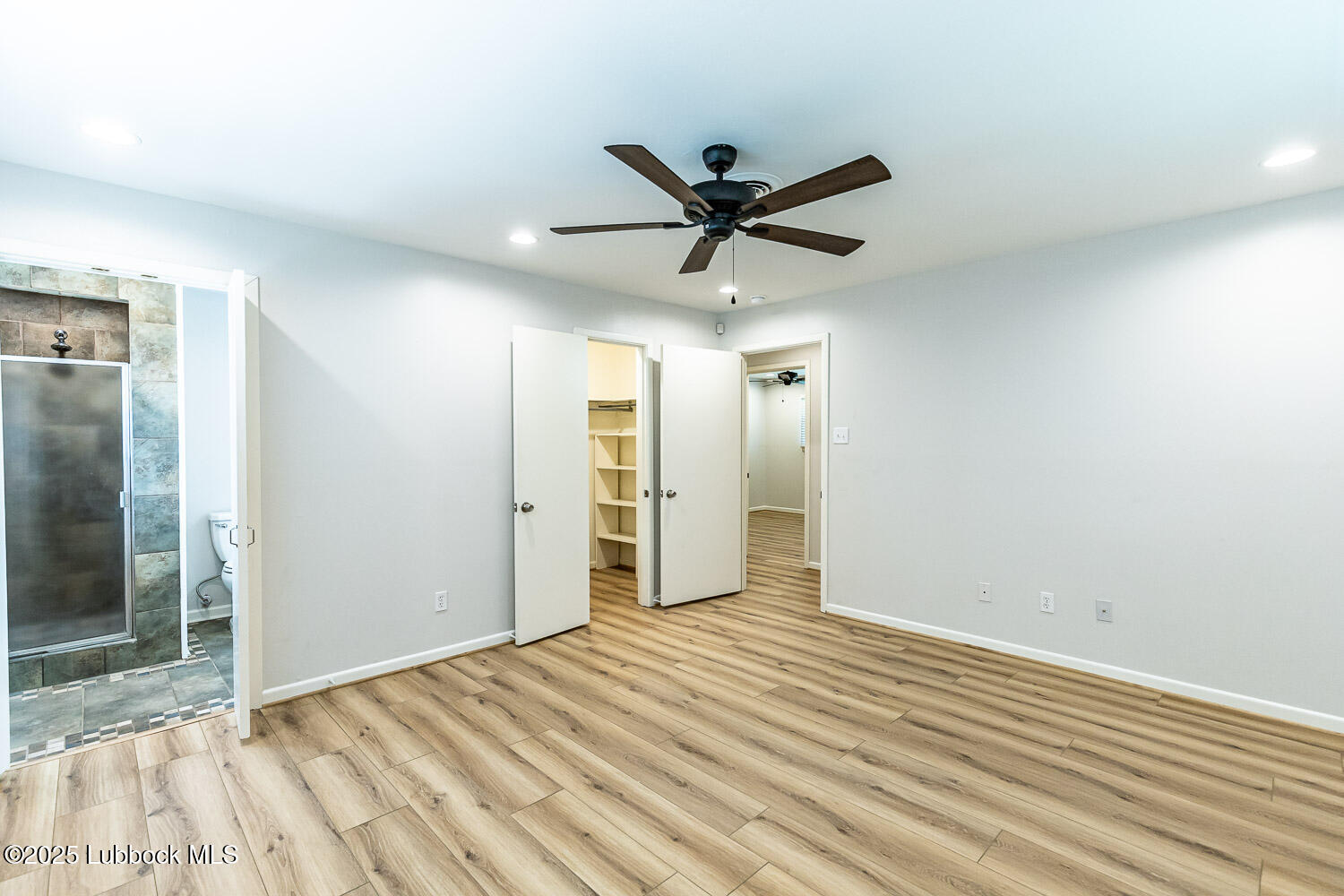 2601 33rd Street Lubbock, TX 79410 - Photo 16 of 30 a view of empty room with wooden floor and fan