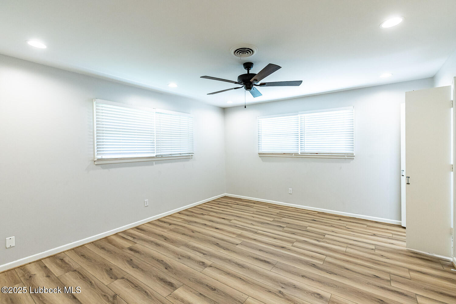 2601 33rd Street Lubbock, TX 79410 - Photo 18 of 30 a view of a room with wooden floor and a ceiling fan