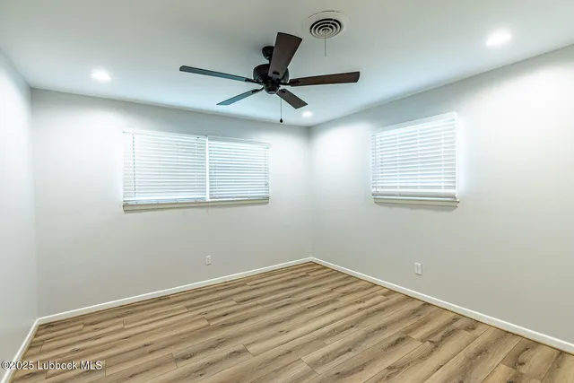 a view of a room with a ceiling fan and a window
